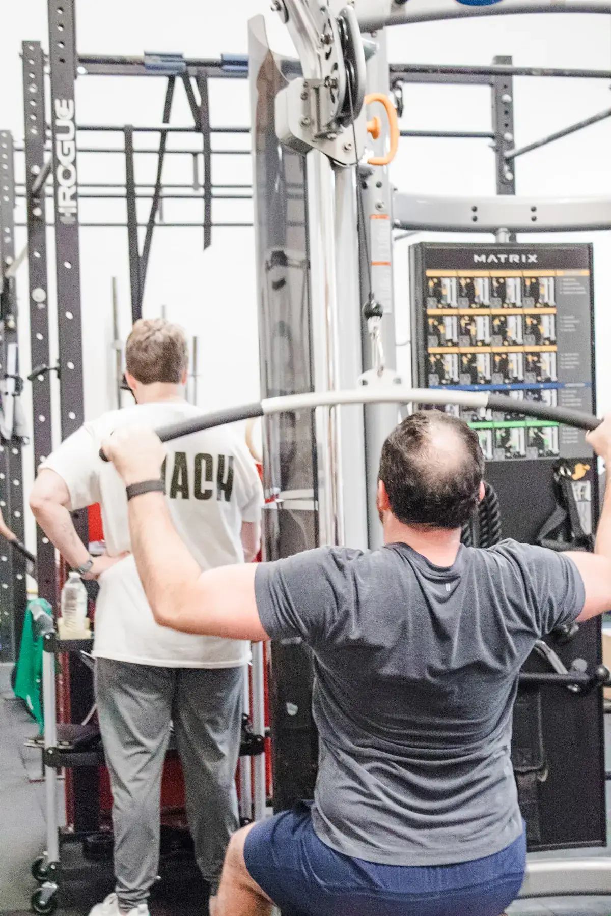 Members on the lat pulldown machine at Paradigm Fitness